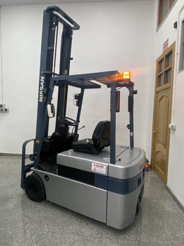 Transpaleta eléctrica de 1600kg en interior con señal de advertencia.