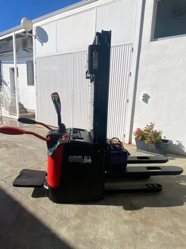 Apilador eléctrico de 1400kg en exterior con control y horquillas largas.